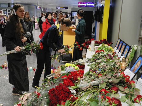 ﻿Люди несуть квіти в аеропорт 