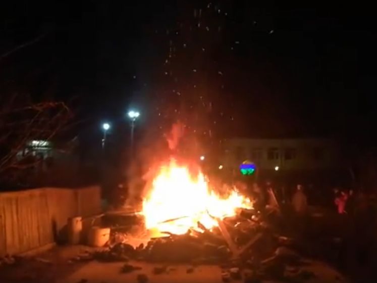 ﻿Перед приїздом автобусів у Нові Санжари поліція відтіснила людей, протестувальники палили багаття на дорозі. Відео