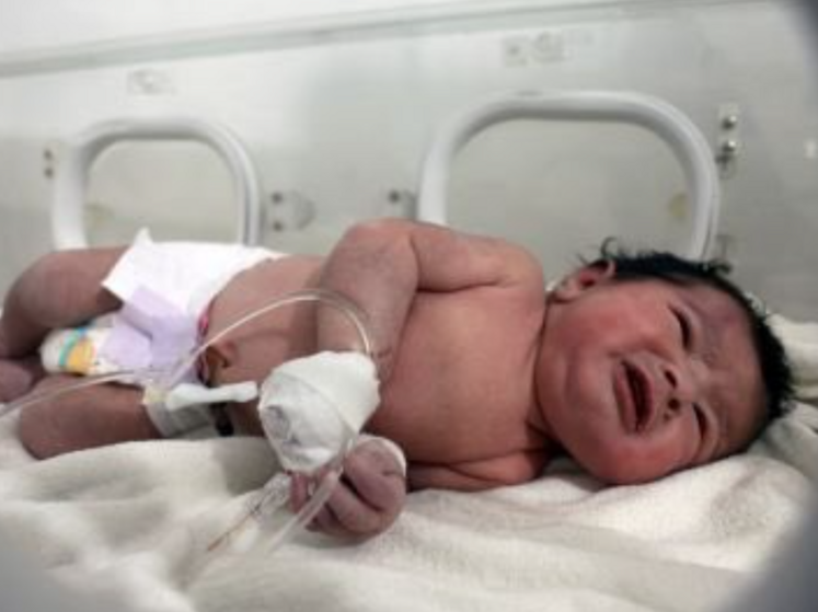 В Сирии из-под завалов дома спасли новорожденного младенца. Он был связан пуповиной с мертвой матерью. Видео