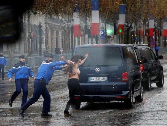 Femen в Париже перед кортежем Трампа оголили грудь с надписью "Фейковые миротворцы"