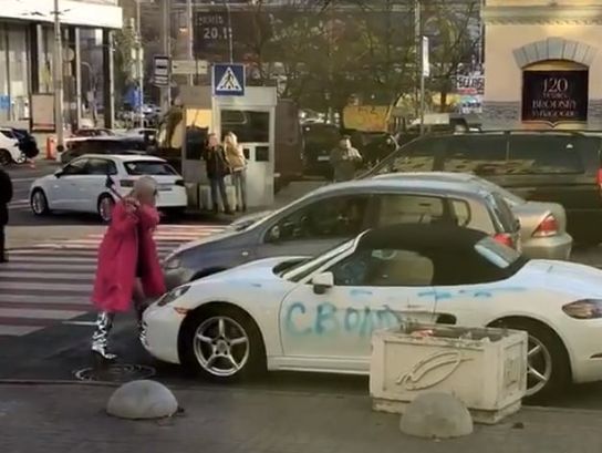 ﻿У Києві білявка в рожевому пальто трощила сокирою Porsche. Виявилося, знімали кліп. Відео