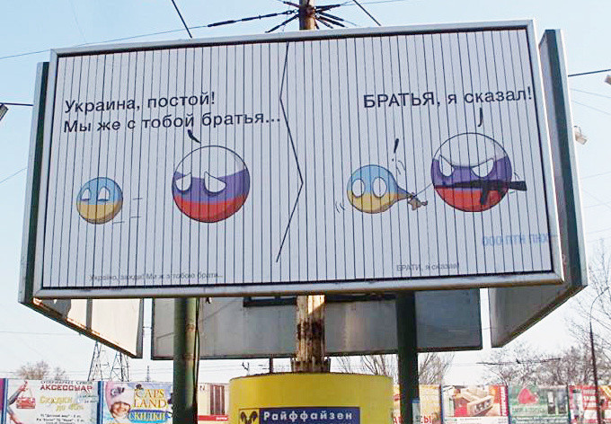 Билборд в Николаеве, на котором изображены два шара, при этом шар, символизирующий Россию с автоматом пытается “отжать” от Украины Крым